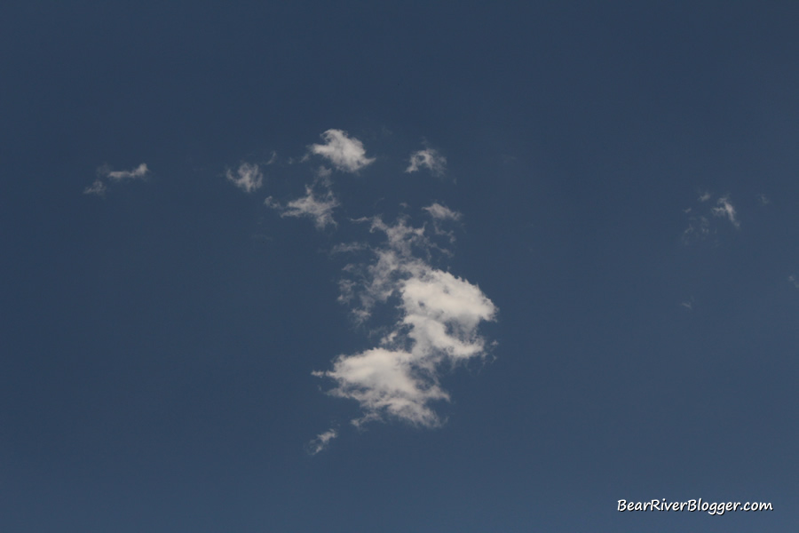 small white cloud starting to fade against a blue sky background