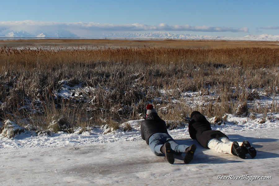 photographers at farmington bay laying down on the ice