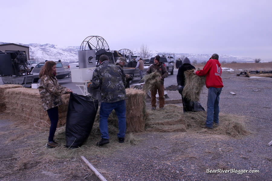 volunteers filling bags with hay for a Canada goose nesting project at Farmington Bay