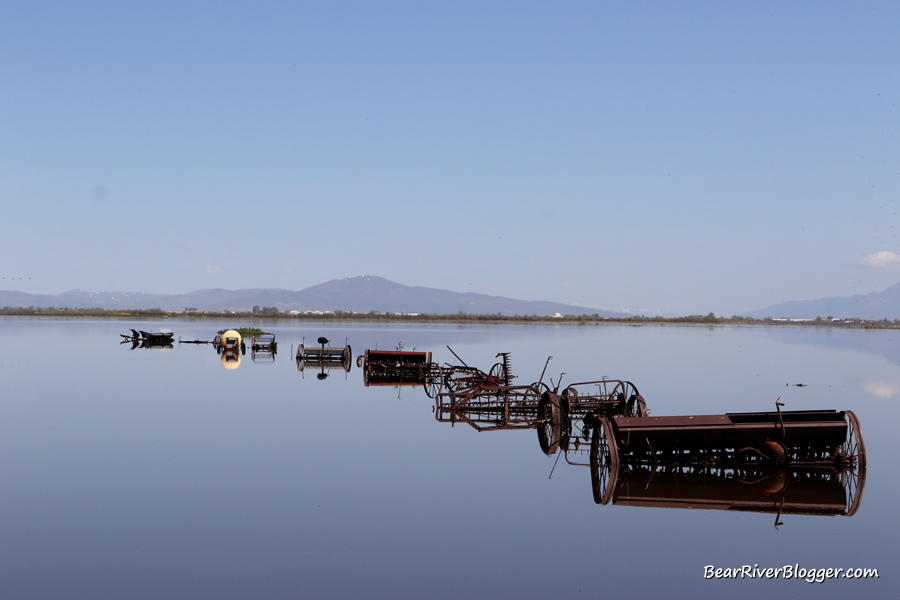 old farm equipment near the bear river migratory bird refuge being surrounded by flood water
