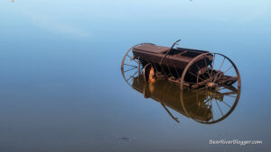 farm equipment on forest street surrounded by flood water