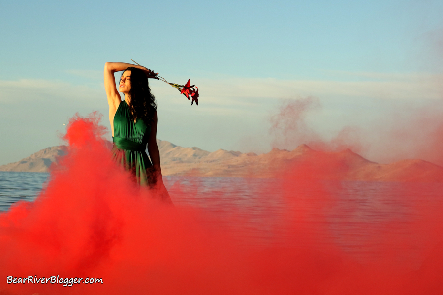 portrait photography session with red smoke in front of a lake